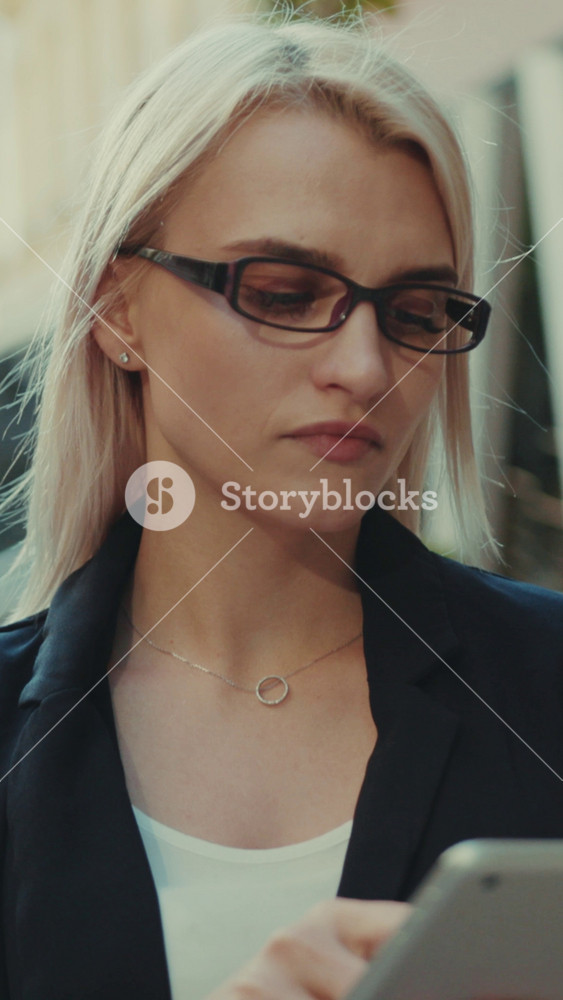 Attractive young woman with glasses use tablet computer look at camera feel happy smile blonde outdoor hair street fashion hand tree girl