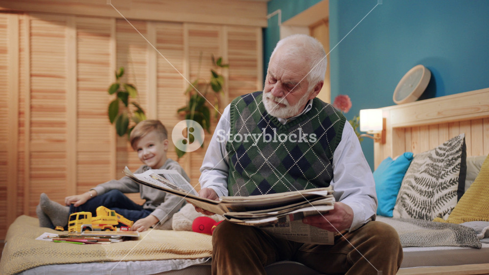 Close up serious grandfather reads the newspaper child play feel happy family grandchild happy love man senior kid two boy grandson elderly