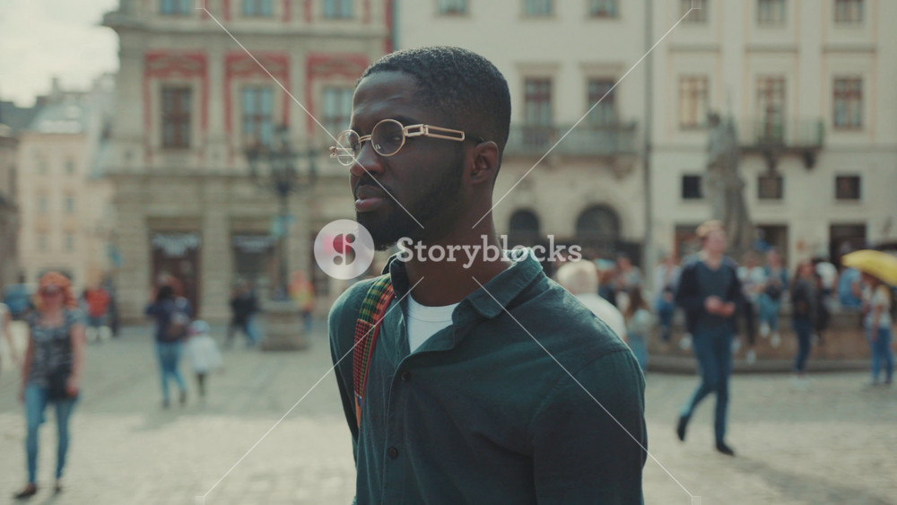 Close up serious face young African American with look at camera standing in city outdoor portrait adult business fashion corporate man