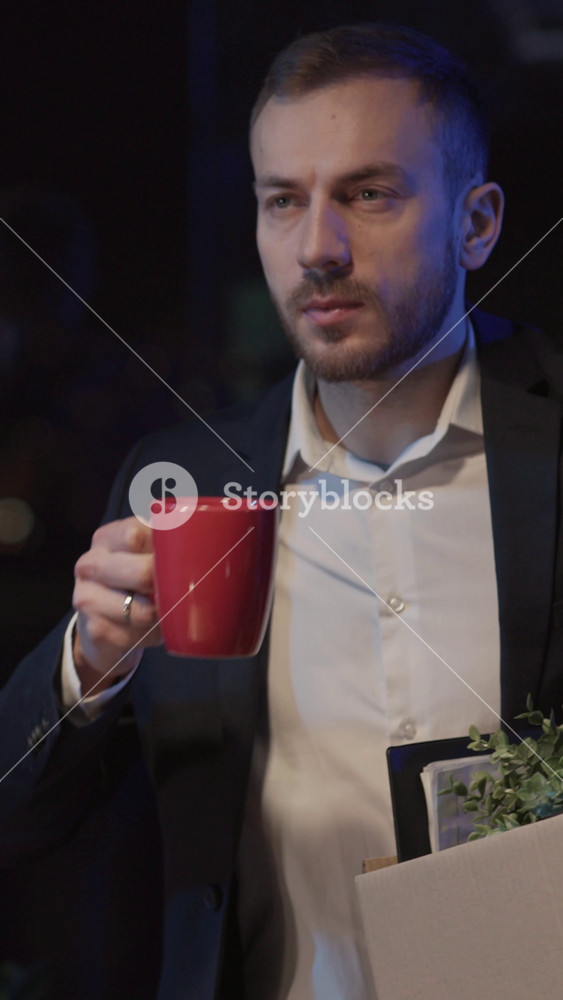 bearded young caucasian man leaving the office quitting job opportunity chaning career ways drinking coffee and collecting office belongings