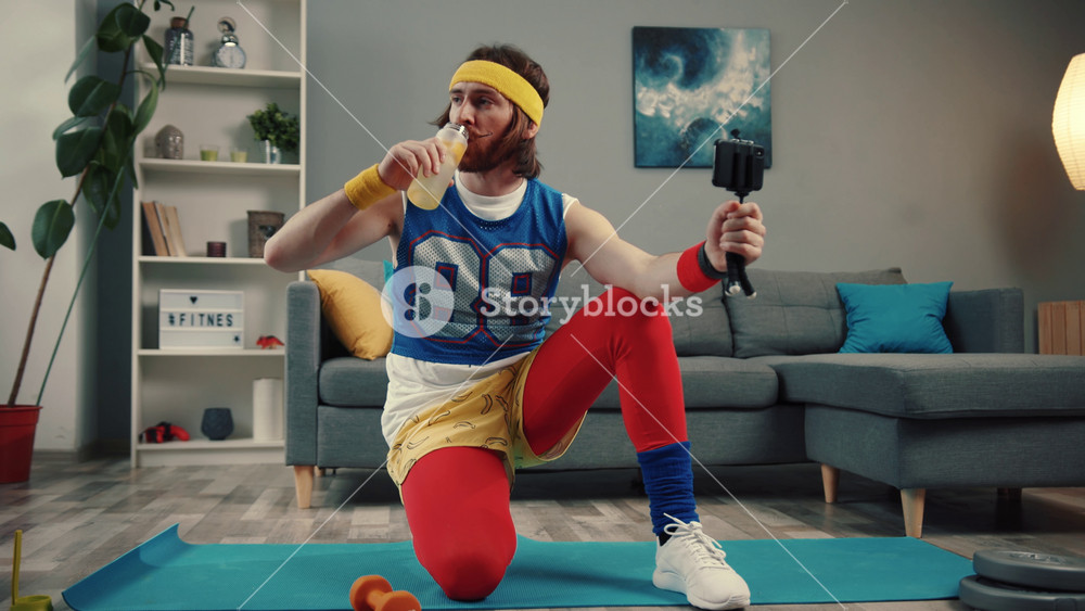 LOS ANGELES, CALIFORNIA, 10 OCTOBER, 2019: Confident male blogger in retro outfit drinking water after exercise recording a video for sports