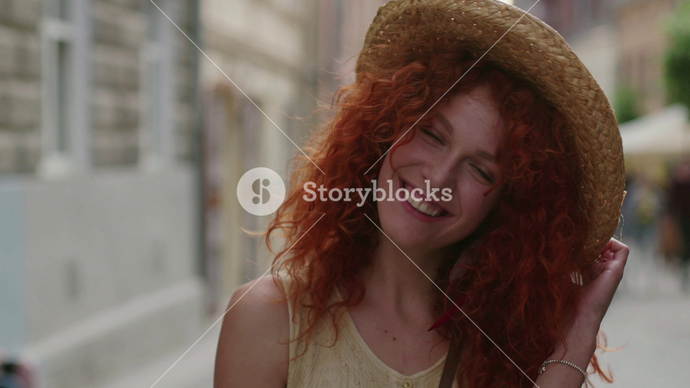 young smiling woman red haired look at camera walking in the city streets happy slow motion summer face technology casual caucasian female