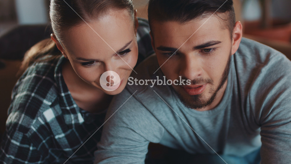 Family home concept, portrait of happy young man and woman with cat sitting at home and trying using laptop personal computer tablet phablet