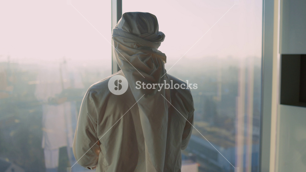 Pensive arab businessman walking into modern office in Dubai contemplating business investment ideas about building new city. Muslim