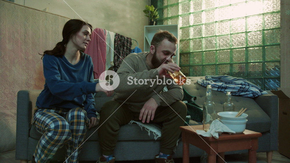 Drunk man hold beer sit on sofa with poor woman feel stress unhealthy alcoholic bottle creepy home desperate depressed unhappy adult
