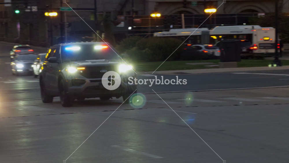 Police car with flashing light going down the street. Night street with patrolling police car. Chicago, IL, USA. 25 September. 2024