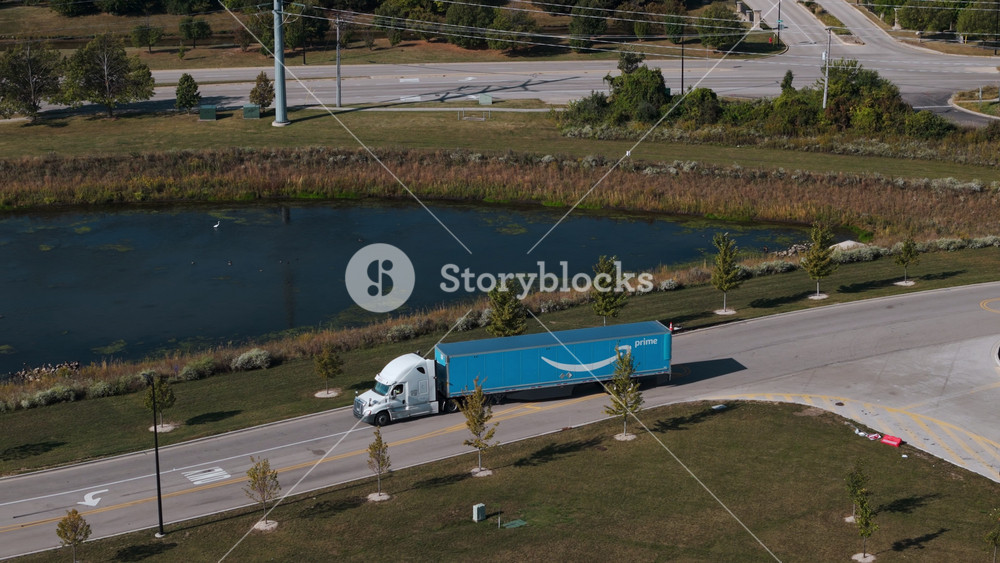 Amazon delivery truck on the road close to the pond in the suburbs. Aerial above shot Naperville IL. USA, September 10 2025