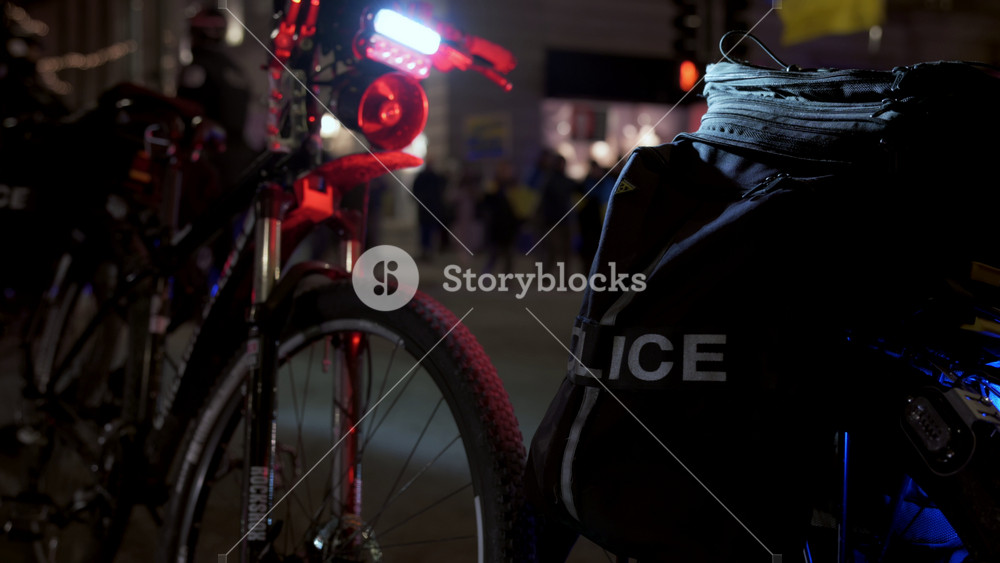 Cars and bicycles of Chicago police department with the flashing lights on at night. The scene of Ukrainian demonstration against russian