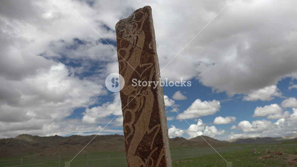 Asian steppe deer stone monument with ancient religious symbols, burial stele, balbal. Archaic ritual obelisk and menhir sculpture showing deer imagery, funerary tomb marker with stone inscription.