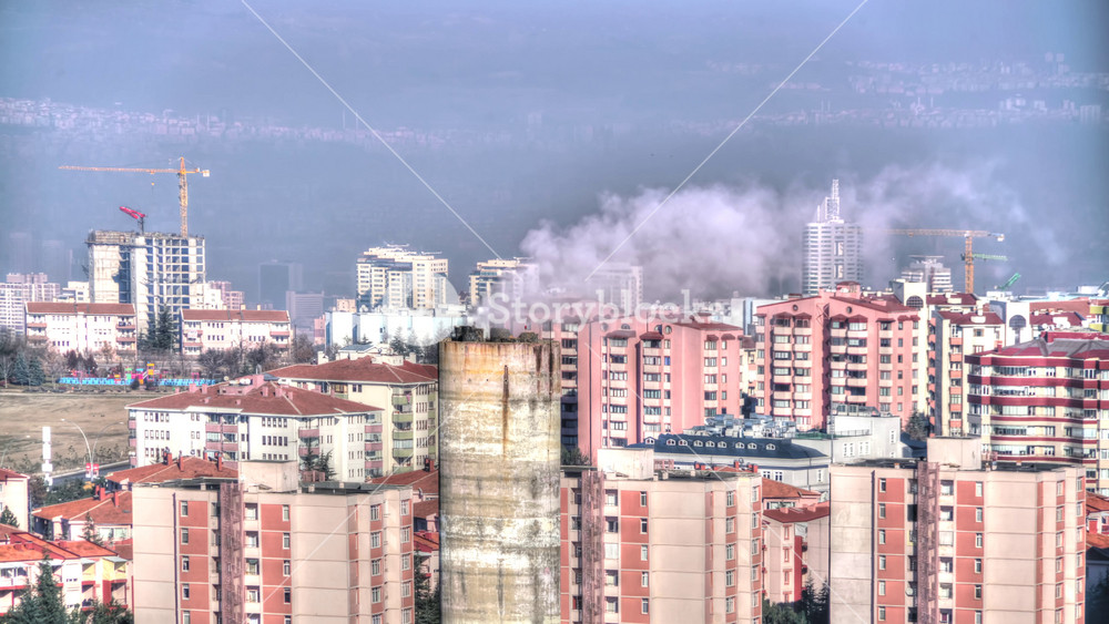 8K Timelapse shows toxic smog layer over apartment city, chimney smoke rising, air pollution. Dark gray haze blankets dense urban skyline, factory stacks emit fumes, residents face health risk.