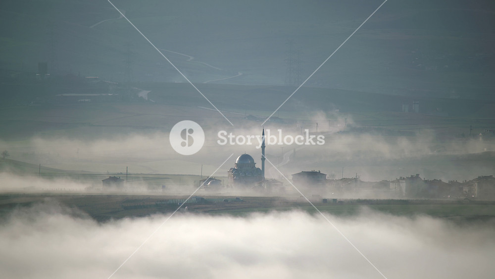 Cinematic 8K timelapse mosque and minaret rising above fog over Eastern Anatolia Turkey. Mystical Islamic shrine on cloud sea near rural village, serene worship landmark at dawn haze.