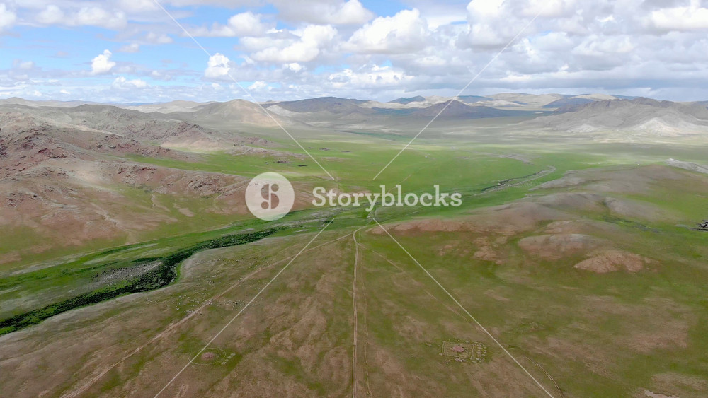 Aerial drone shows ancient kurgan burial monuments across Central Asian ritual landscape. Sacred stone circles and burial mounds reveal prehistoric ritual traditions of nomadic steppe cultures.