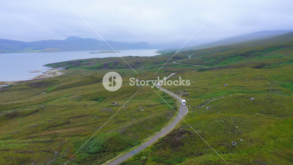 Aerial Drone View of Scotland Highlands Road Trip Driving Holiday in Mountains, with Car on Scottish Roads of NC500 (North Coast 500 Route)