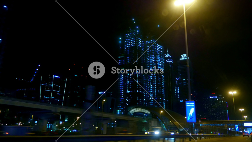 A trip through night Dubai with a view of illuminated skyscrapers and city traffic. Urban landscape of one of the most modern cities in the world.