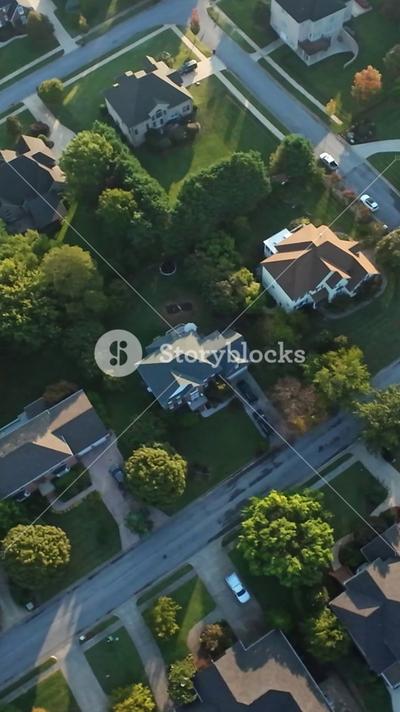 Vertical Screen, Johnson City, USA, Tennessee - Evening Aerial view Over TreeLined Houses in Golden Hour Glow On Roofs And Lawns with Tidy Driveways