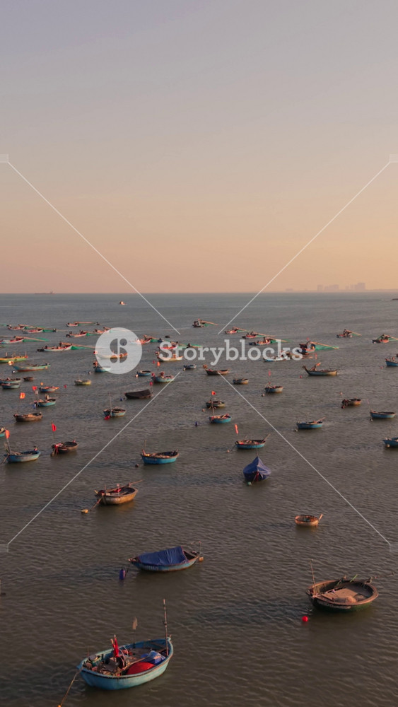 Vertical screen Da Nang Basket Boats At Sunset, Warm Golden Sky And Clusters Of Round Vessels Drifting Toward Shore, Asian Fisherwomen