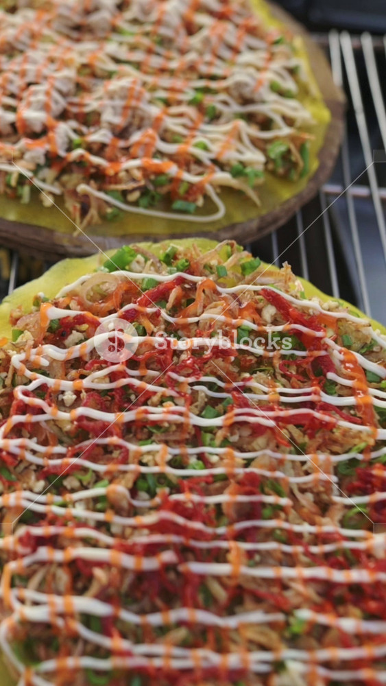 Vertical screen Grilled Rice Paper Pizza Drizzled With Mayonnaise And Chili, Closeup Of Vendor Stall At Vietnamese Street Market, Shredded