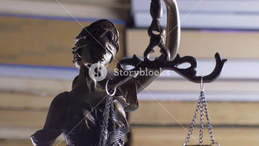 Statue of Themis or Lady Justice on bookshelf background. Law Firm or Business Concept. Corporate or business, enterprise or company law