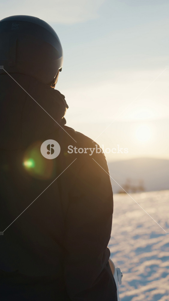 Female snowboarder looking at slope of ski resort in winter, back view. Tourist tour in mountains, woman admiring landscape before riding by