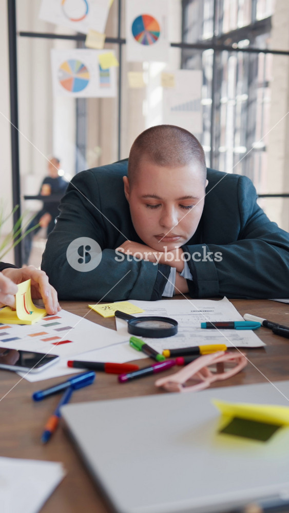 Vertical portrait of sleeping woman in boring business meeting in office, young adult lady lying at table. Tired and exhausted office worker