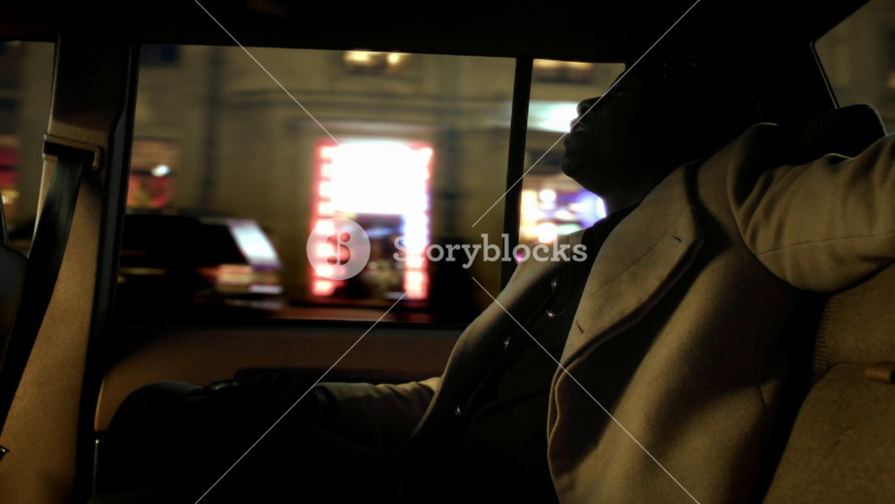 Black rapper flowing in backseat of taxi, cool African guy singing his own songs . Talented rapper, African American male person riding by