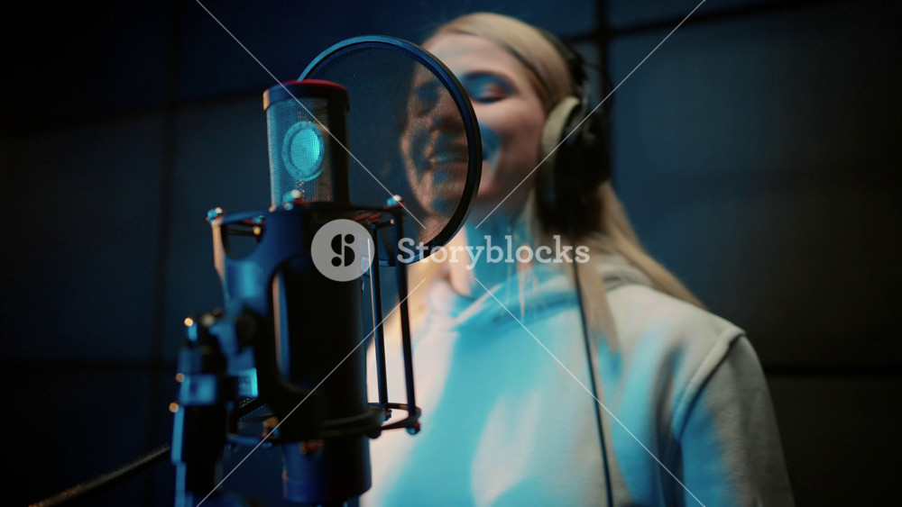 Modern sound studio for recording music, portrait of singing woman singer. Record of soundtrack, musical or voice acting, young adult lady