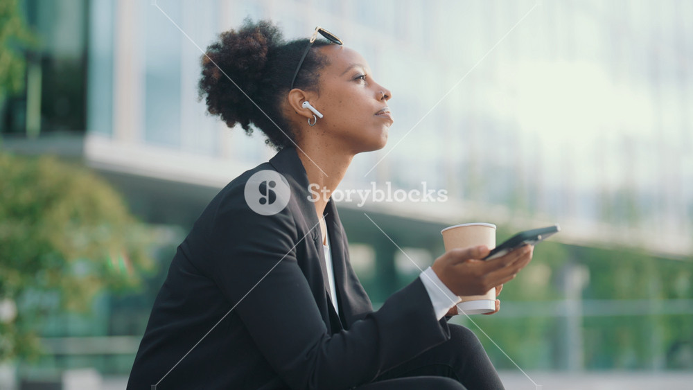 Woman listening to voice message by and in city street. Office worker or businesswoman relaxing after long working day, sitting in park and
