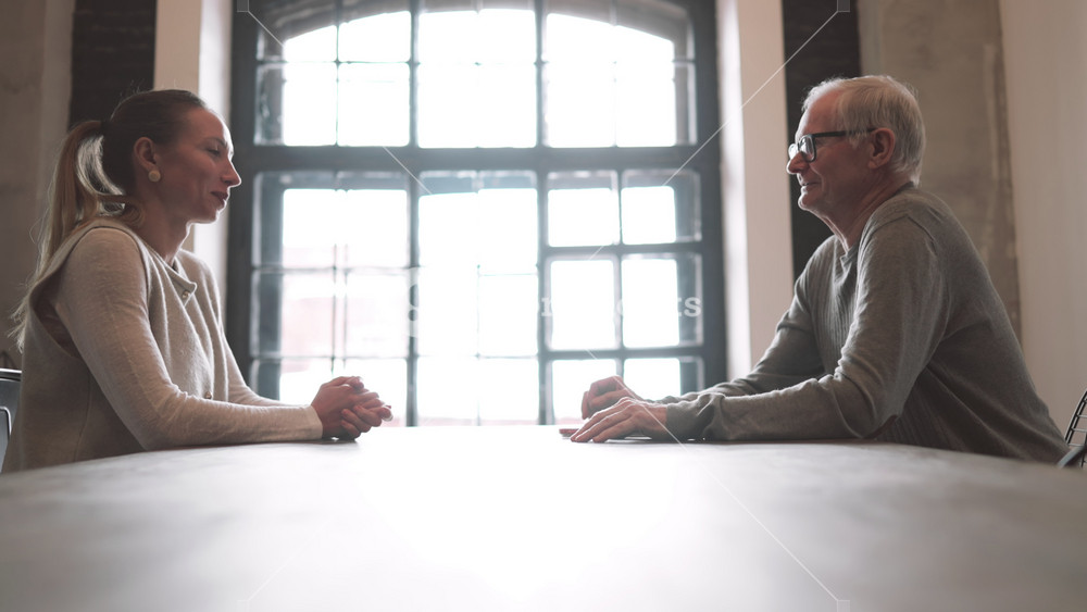 Job interview in modern office, boss and candidate talking cheerfully and kindly. Female employee and senior male head of company discussing