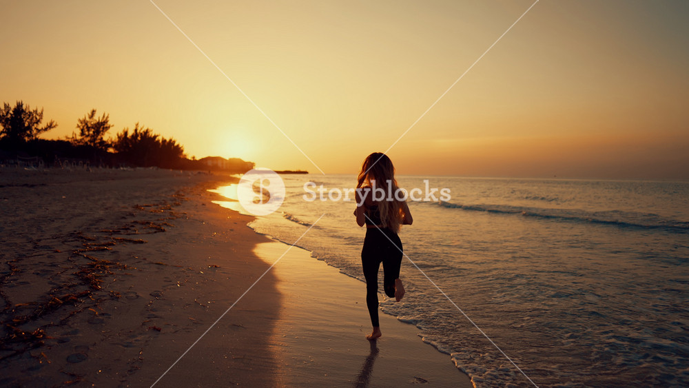 Jogging and run in morning, healthy lifestyle, woman running alone along ocean. Cinematic slow motion shot with beautiful lady in skinny