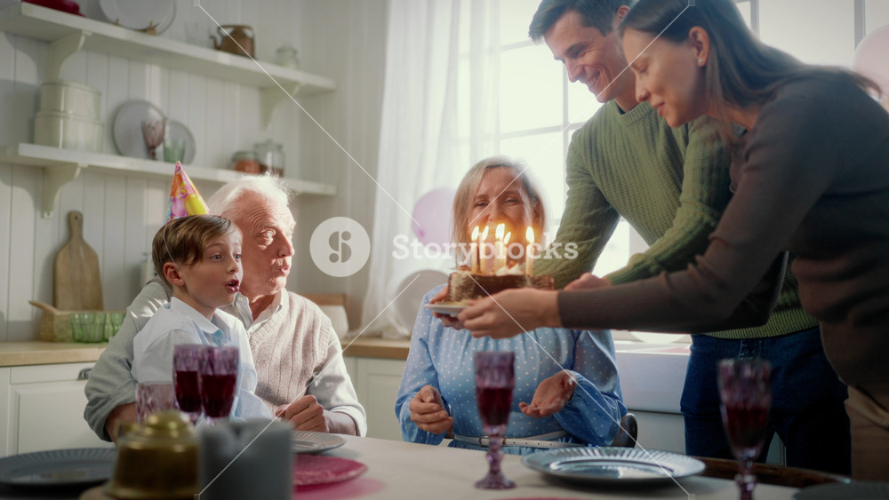 Family values and tradition, celebrating birthday of child with cake and candles . Happy little boy enjoying joint time with parents and