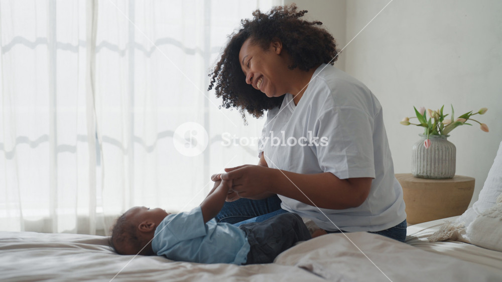 Happy family moments. African american mother playing with infant and smiling. Childhood and motherhood, parenting, black woman spending