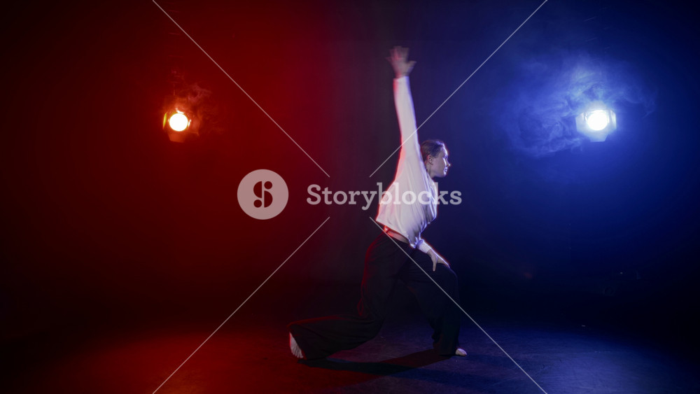 Female figure in dance hall, lady dancing alone, red and blue light, slow motion . Active dance of young adult woman in casual clothes