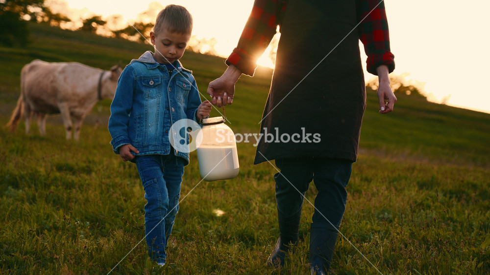 Cute little boy helping to her mother in farm, son and mom carrying milk . Summer vacation in countryside, beautiful grazing lawns in eco