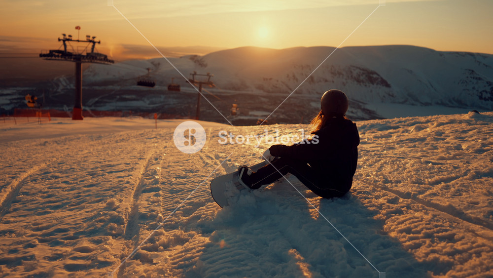 Spend winter holidays in mountains, do winter sport, woman snowboarder at top. Rest in modern luxury ski resort, sportswoman sitting on