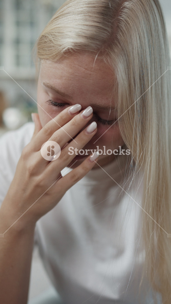 Vertical portrait of depressed crying woman after quarrel with husband or boyfriend. Beautiful blonde lady feeling sadness and frustration