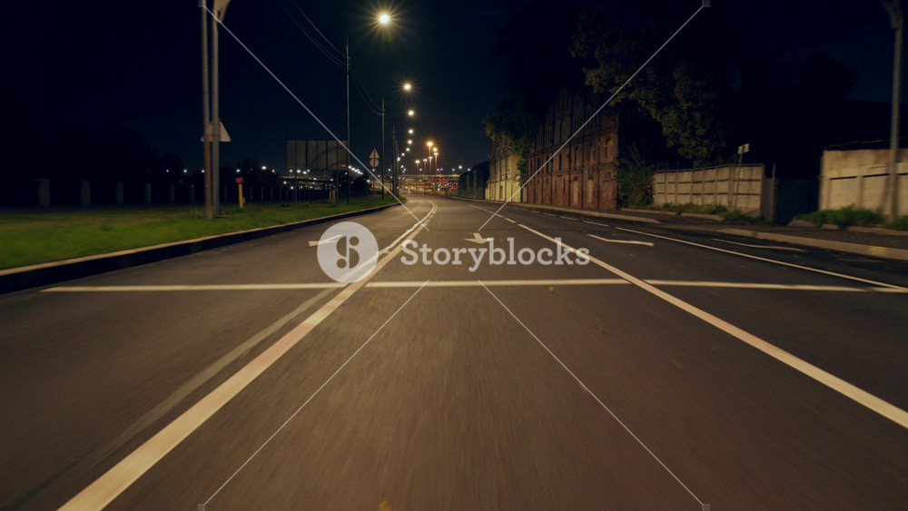 Highway in outskirts, view from rear window of car or bus, riding on city roads. Travel by automobile road across country, street lamps