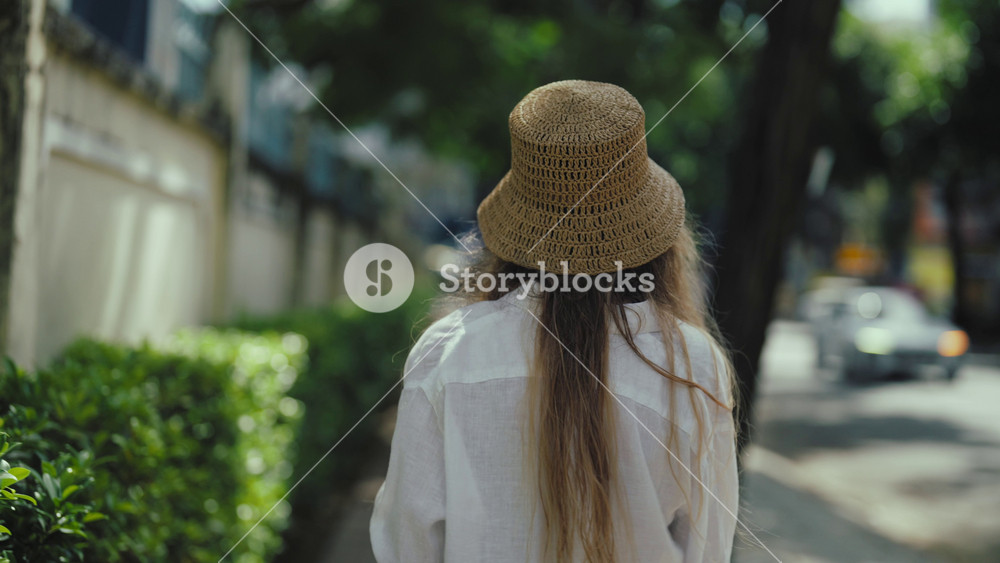 Beautiful blonde woman walking street in sunny city, back view of female tourist. Traveling and exploring new countries, enjoy architecture