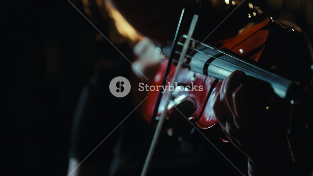 Music in night, closeup of violin and bow in hands of talented lady musician. Romantic melody and sounds of night rain, music of nature