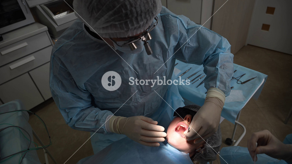 Beautiful Woman in dentist chair at appointment with dental surgeon during wisdom tooth removal and dental care process. 4k 120 fps slow