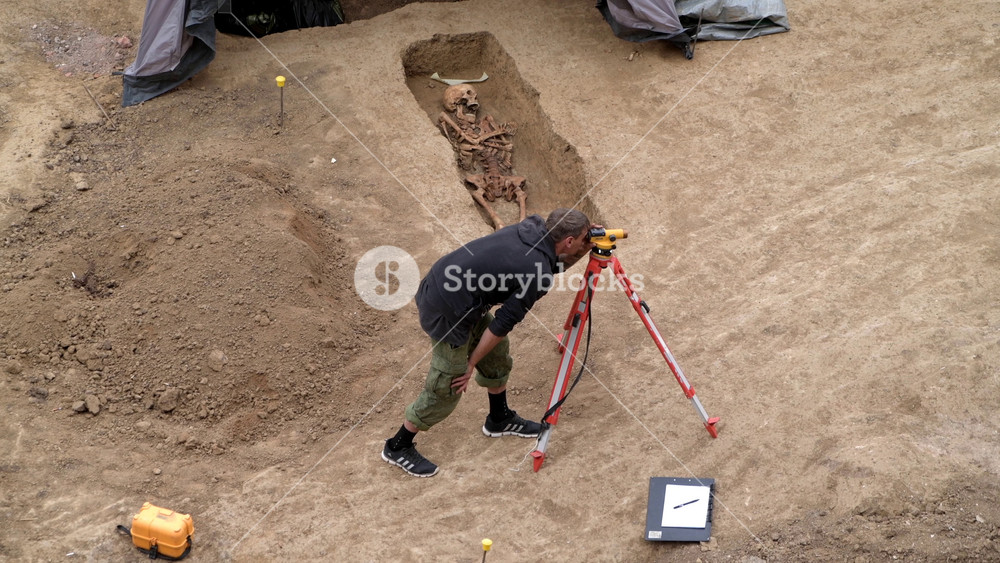Rostov-on-Don, Russia - 15 September 2022: Group of Archaeologists uncover ancient skeletons in well-preserved grave at desert excavation