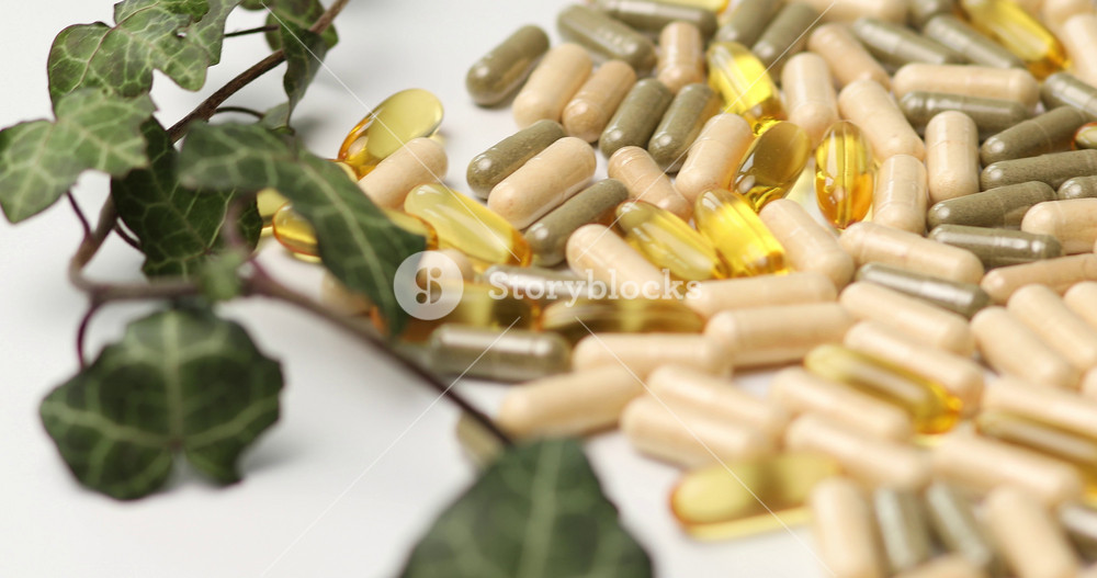 Rotation of Pills, medical tablets with green plants, leaves on white background, Natural herbal medicine concept, Vitamins and omega oils for vegans