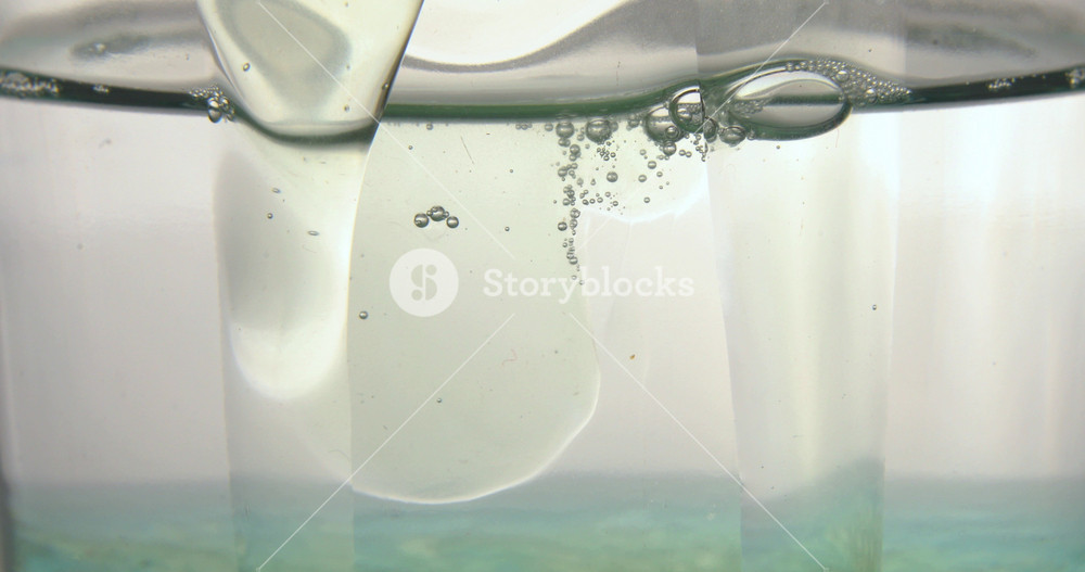 Close up of blue bubble serum poured in a medical glass bottle, background, natural essential oil, cosmetic, medicine.