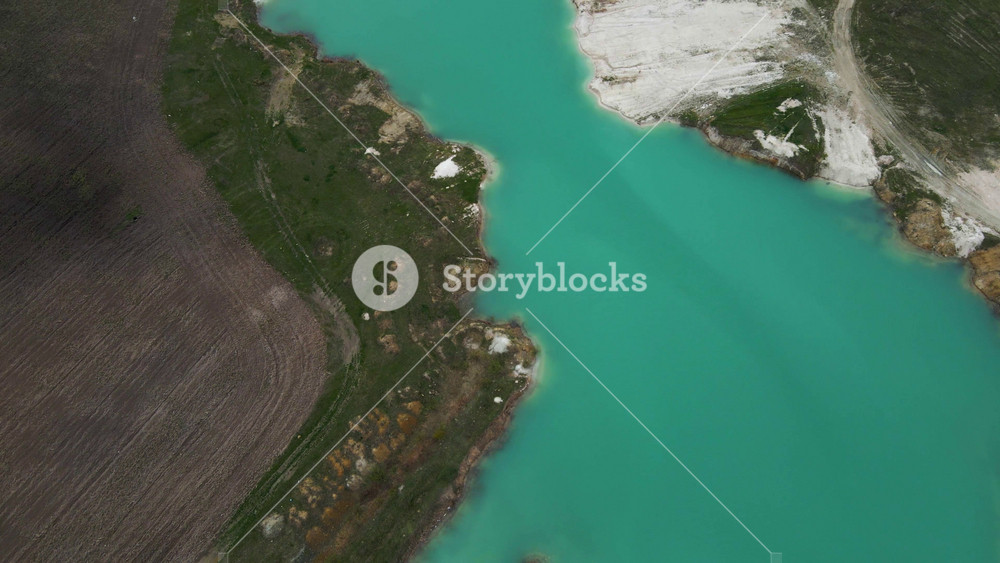 Aerial drone view Amazing industrial landscape, on Emerald lake in a flooded quarry, opencast mine. Oval lake in industrial crater, acid mine drainage, Open pit mine with lake.