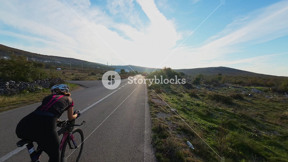 Cyclist on winding mountain road at sunset surrounded by vibrant autumn foliage ideal for travel adventure outdoor fitness nature and