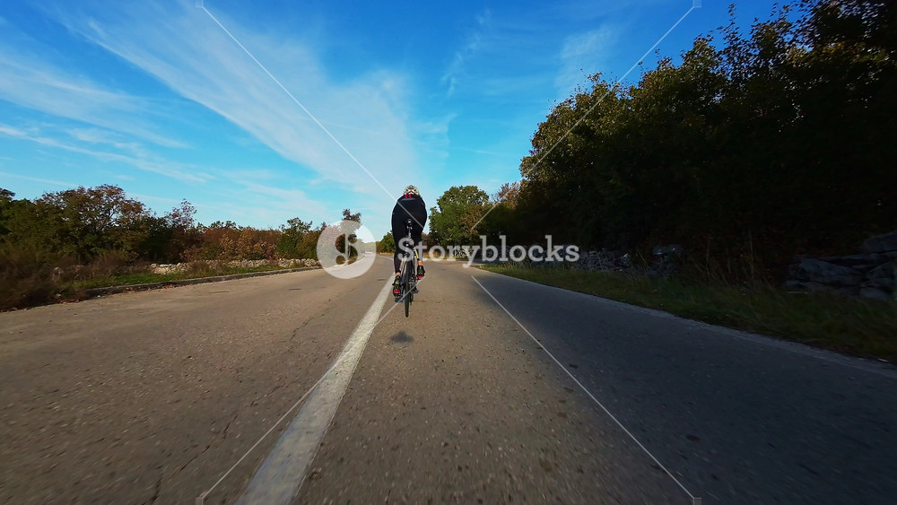 Cyclist on winding mountain road at sunset surrounded by vibrant autumn foliage ideal for travel adventure outdoor fitness nature and