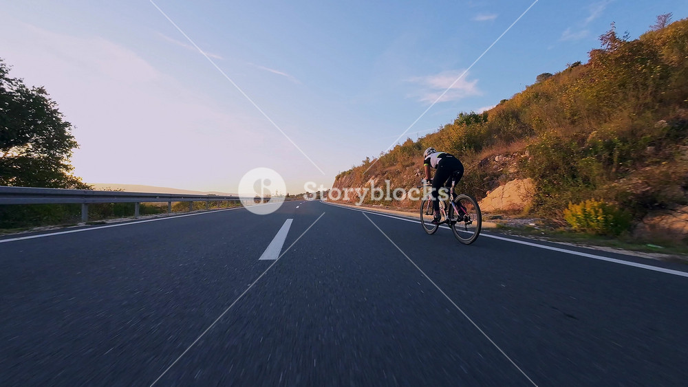 Female cyclist on mountain road at sunset surrounded by vibrant autumn foliage ideal for travel adventure outdoor fitness nature and