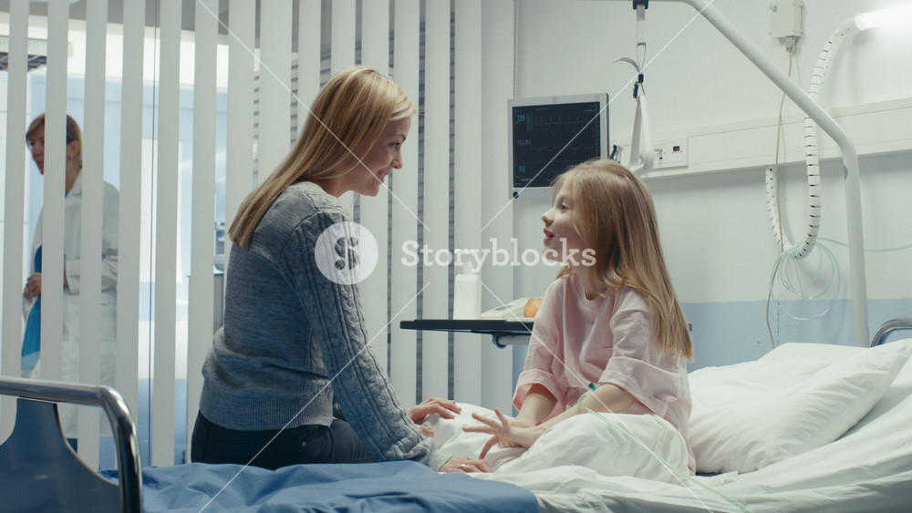 Healed Little Girl Sits on a Hospital Bed and Chats with Her Mother. Children's Hospital Pediatric Ward. Top Quality Health Care.