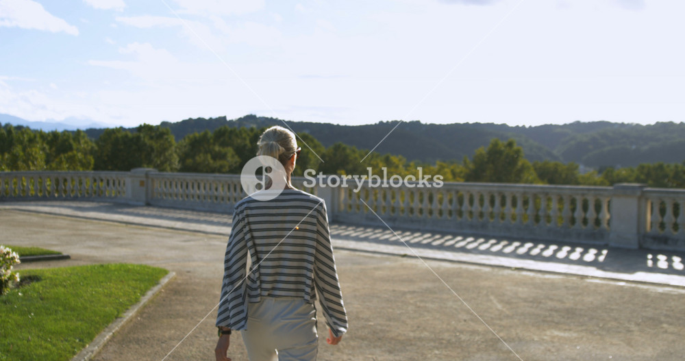 Stylish Young Woman Walks on the Old Town Observation Terrace with Balustrade. Beautiful Person with Historic Architecture and Picturesque Nature.