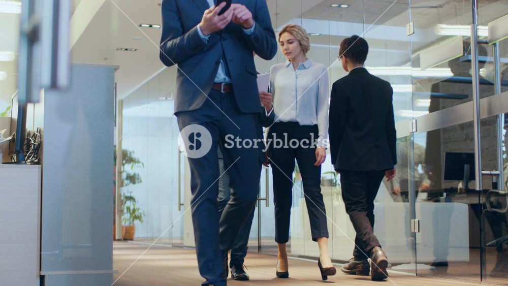 Low Angle Shot of the Business People Walking Through the Corporate Building Hallway. Multicultural Crowd Of Businessmen and Businesswomen Busily Going about Their Business.