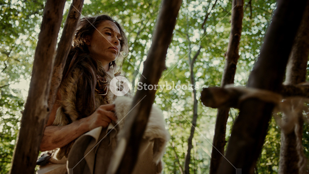 Prehistoric Cave Woman Handles Animal Skins, Furs and Hides. Primitive Neanderthal Woman Lifestyle Surviving, Doing Cave Chores and Household Work